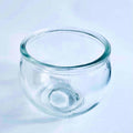 Transparent round glass candle holder with thick rim on white surface